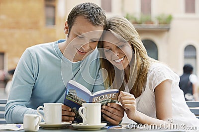 Couple Reading Guidebook At Cafe Stock Photo