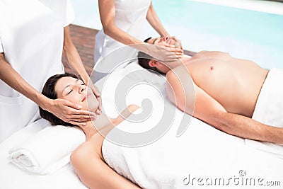 Couple receiving a face massage from masseur Stock Photo