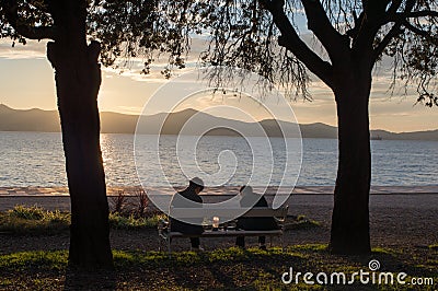 Couple relaxing on a bench during the sunset Editorial Stock Photo