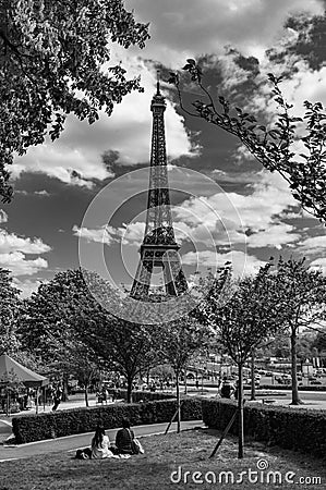 Couple relaxing near the Eiffel Tower in Paris Editorial Stock Photo