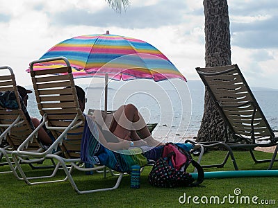 Couple relaxing under colorful umbrella Editorial Stock Photo