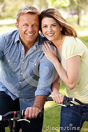 Couple riding bikes in park Stock Photo