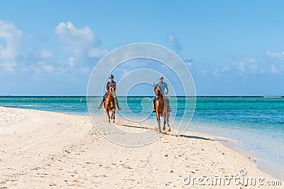 Couple riding on horseback along the sea Editorial Stock Photo