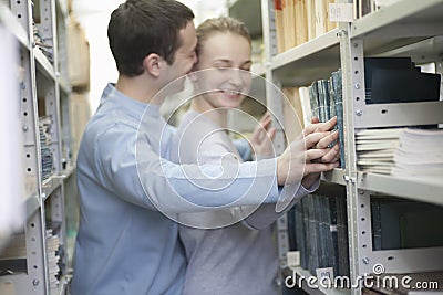Couple Romancing In Library Stock Photo