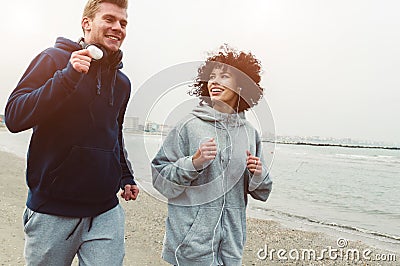 Couple of runners training at the beach in winter Stock Photo