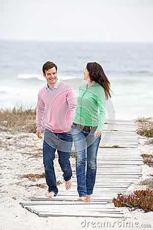 Couple running along beach path holding hands Stock Photo