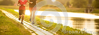 Couple running outdoors, at sunset, by a river Stock Photo