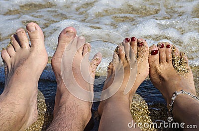 A couple`s feet on the background of the sea. Stock Photo