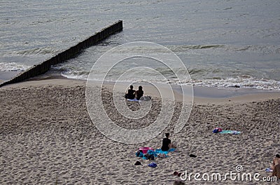 Couple seating together on Baltic Sandy Beach Back Shot of girl Editorial Stock Photo