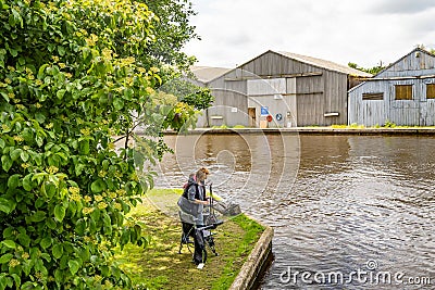 Anglers fishing the River Bure in the village of Hoveton and Wroxham Editorial Stock Photo