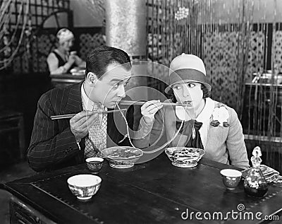 Couple sharing a noodle in a restaurant Stock Photo