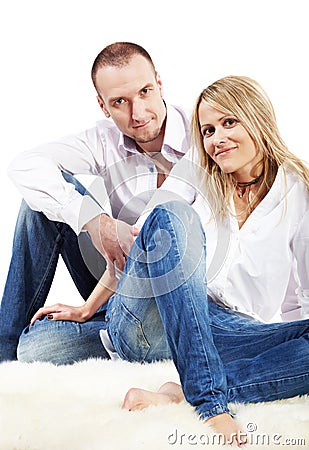 Couple sits on the hairy white carpet Stock Photo