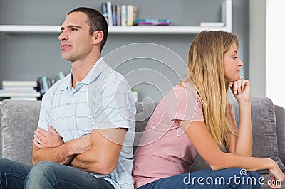 Couple sitting back to back after a fight on the couch Stock Photo