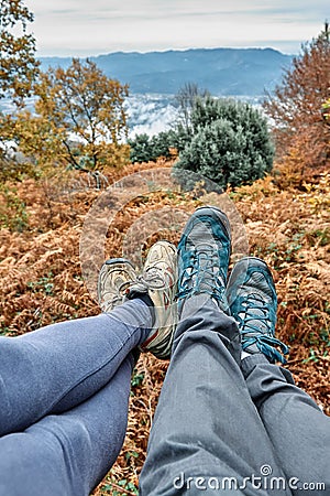 Couple sitting in the forest, only the feet and shoes are visible. Unrecognizable persons Stock Photo