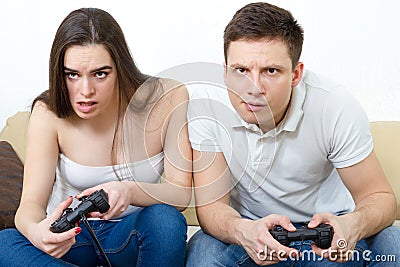 Couple sitting in living room and play video games on console o Stock Photo