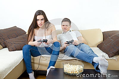 Couple sitting in living room and play video games on console o Stock Photo