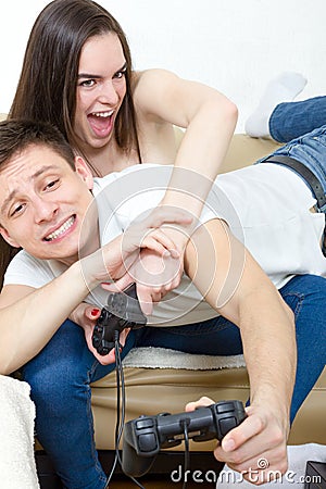 Couple sitting in living room and play video games on console o Stock Photo