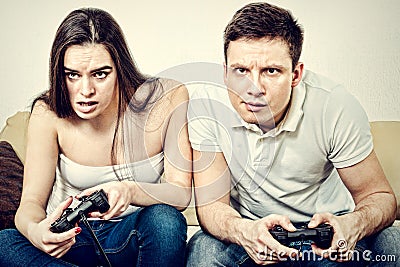 Couple sitting in living room and play video games on console o Stock Photo