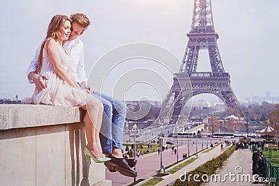Couple sitting near Eiffel Tower in Paris, honeymoon in Europe Stock Photo