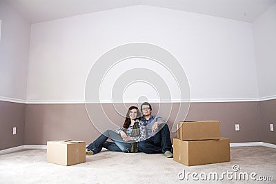 couple sitting in new home on moving day Stock Photo