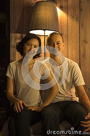 Couple sitting beside in room. Warm tone photography. Stock Photo