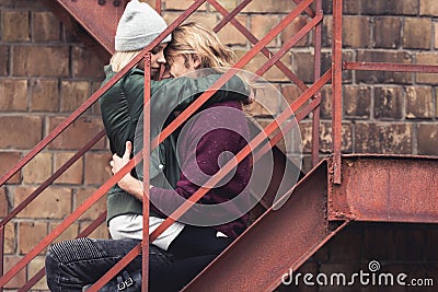 Couple sitting on stairs and embracing Stock Photo