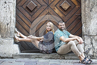 Couple sitting on the steps of the old house. Portrait of loving couple, young family. Stock Photo