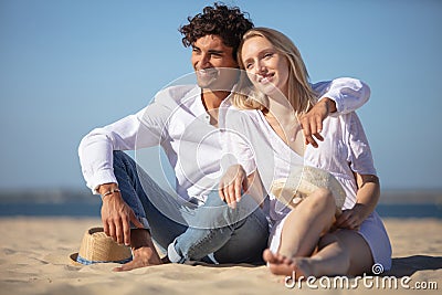 couple sitting together on beach and enjoying tranquillity Stock Photo