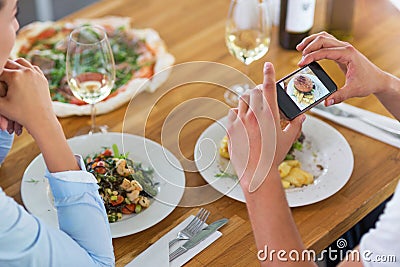 Couple with smartphone photographing food at cafe Stock Photo