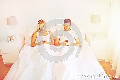 Couple with smartphones in bed Stock Photo