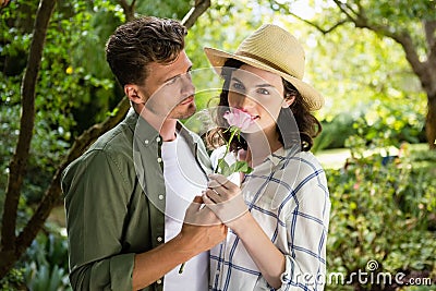 Couple smelling flower in garden Stock Photo
