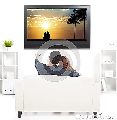 Couple on sofa watching TV with remote control Stock Photo