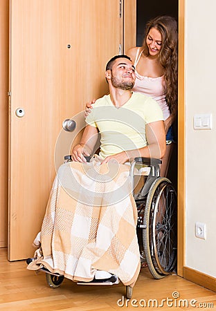 Couple with spouse in wheelchair near door Stock Photo