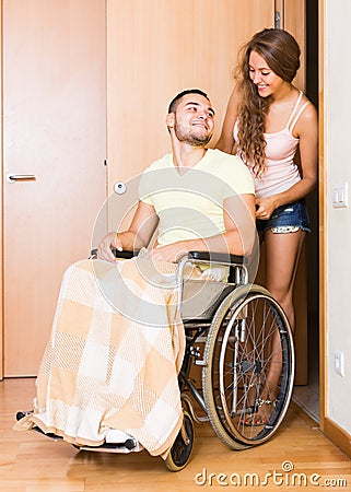 Couple with spouse in wheelchair near door Stock Photo