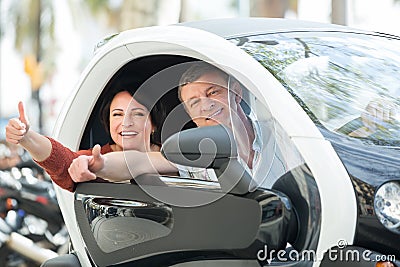 Couple standing near twizy electric Stock Photo