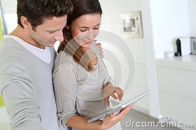 Couple standing togeteher at home with tablet in hands Stock Photo