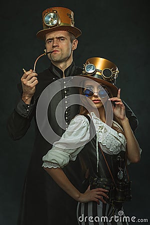 The couple steampunk. A man with a pipe and a girl with glasses Stock Photo