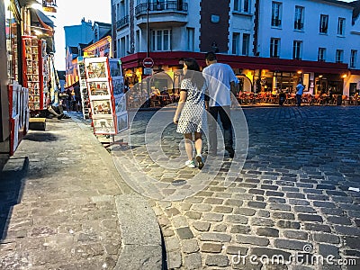 Couple strolls past tourist print shop on Montmartre, Paris, France Editorial Stock Photo