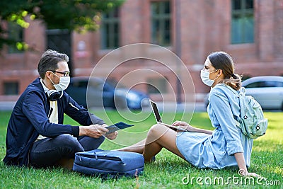 Couple of students in the campus wearing masks due to coronavirus pandemic Stock Photo