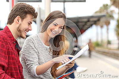 Couple of students studying in a train station Stock Photo