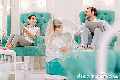 Couple of successful businessmen coming to salon for feet massage Stock Photo