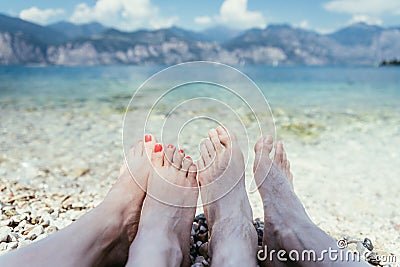 Couple in the summer holidays: Feet in the crystal clear water Stock Photo