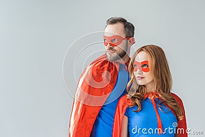 couple in superhero costumes standing together and looking away Stock Photo