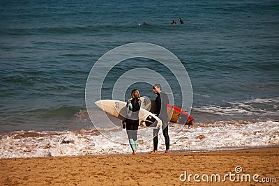 A couple of surfers with their boards in Zarautz 2 Editorial Stock Photo