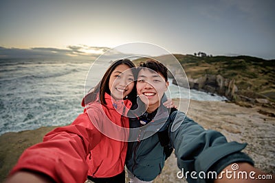 Couple takes selfie image at coastal scenery near Dunedin in New Zealand Stock Photo