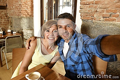 Couple taking selfie photo with mobile phone at coffee shop smiling happy in romance love concept Stock Photo