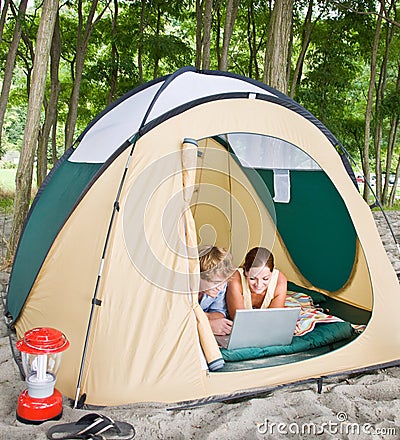 Couple in tent using laptop Stock Photo