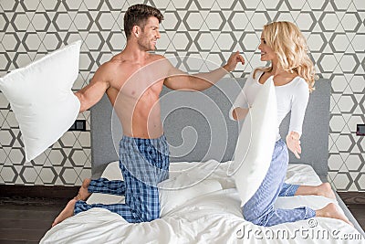 Couple in their sleepwear having a pillow fight Stock Photo