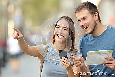 Couple of tourists checking location on the street Stock Photo