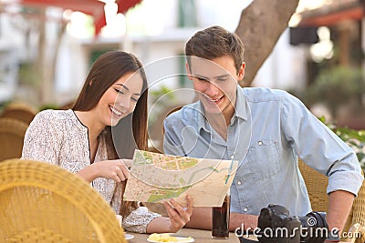 Couple tourists consulting a guide in a restaurant Stock Photo